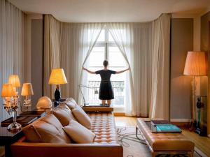 巴黎莱佛士皇家巴黎梦索酒店的站在客厅的女人,从窗户望出去