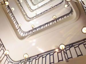 巴黎莱佛士皇家巴黎梦索酒店的白色的螺旋楼梯,有灯光