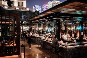 迪拜Ritz Carlton Residences DIFC Downtown Dubai的城市里有人坐在桌子上的酒吧