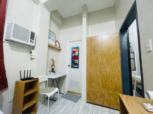 维拉克Cozy 1BR Unit with Full Bathroom,Kitchen, Wifi at Sonia's Island Stay的一间设有门、桌子和书桌的房间