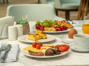 索非亚Maison Sofia - MGallery的一张桌子,上面放有奶酪、水果和鸡蛋