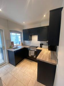 Isham4 Bedroom House For Corporate Stays in Kettering的厨房配有黑色橱柜和水槽