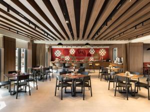 地拉那Mercure Tirana的餐厅设有木制天花板和桌椅