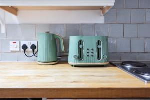 伦敦Stylish Apartment in Putney的厨房台面上有两个绿色烤面包机