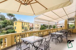 拉帕洛HOTIDAY Hotel Rapallo的阳台配有桌椅和雨伞。