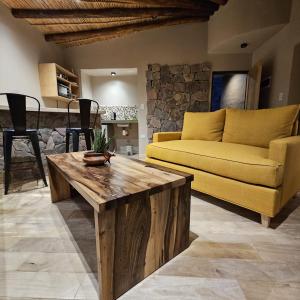 普尔马马尔卡Cabañas Bodega Kindgard的客厅配有黄色沙发和木制咖啡桌