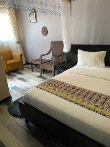 姆巴拉拉Life Lounge Guest house的配有一张床和一把椅子的酒店客房