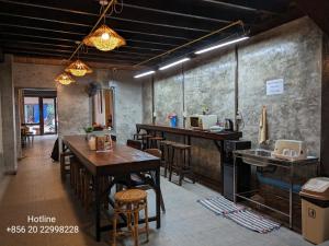 他曲STAY Hostel & Motorbike Rental - Thakhek的餐厅设有木桌、椅子和柜台