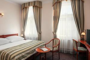 布拉格阿米戈城市中心酒店的酒店客房设有一张床、一张书桌和两个窗户。