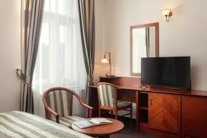 布拉格阿米戈城市中心酒店的酒店客房配有一张书桌、一台电视和一张床
