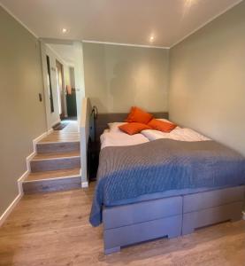 代特莫尔德Little Lopsi的一间卧室配有带橙色枕头的床和楼梯。