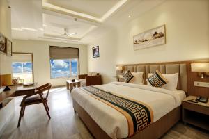 新德里Hotel Aerotech Near Delhi Airport的酒店客房设有一张大床和一张书桌。