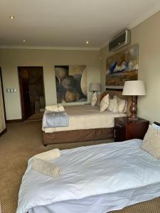 贝拉贝拉Elements golf reserve的一间卧室设有两张床,墙上挂着一幅画