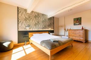 绍德方丹Côté cour, côté source chambre d'hôtes的卧室配有一张床,墙上挂有绘画作品