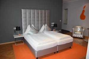 阿姆施泰滕古德勒城市酒店的卧室内一张带大床头板的大型白色床