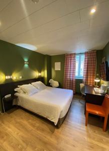 沙勒维尔-梅济耶尔鹈鹕酒店的酒店客房配有一张床、一张书桌和一张四柱床