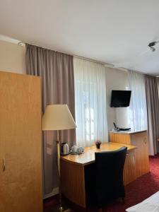 柏林波恩福德（万湖-霍夫）酒店的酒店客房配有书桌和电视。