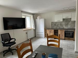 什切青Apartamenty Bezrzecze的厨房配有桌椅和冰箱。