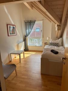 布赫洛厄Landhaus Lindenberg的一间卧室配有一张床、一张桌子和一个窗户。