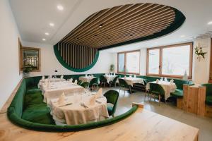 菲耶梅堡奥利派尼克酒店的餐厅设有白色的桌子和绿色的椅子