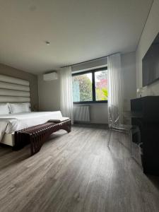 都灵帕可莎西酒店的一间卧室配有一张床、一个窗口和一张书桌