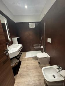 都灵帕可莎西酒店的浴室配有2个盥洗盆、卫生间和淋浴。