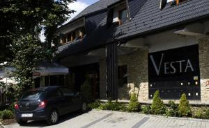 耶莱希尼亚Hotel Vesta Centrum Konferencyjno Wypoczynkowe的停在大楼前的一辆黑色汽车