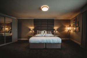 科格索尔埃塞克斯高尔夫&乡村俱乐部酒店的一间卧室配有一张大床和两盏灯。
