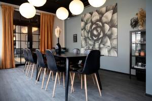 哥本哈根Bob W Østerbro Copenhagen的一间用餐室,配有黑色的桌子和椅子