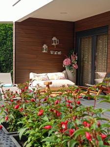 桑提亚纳德玛Norte de Santillana的带沙发和红花灌木的天井