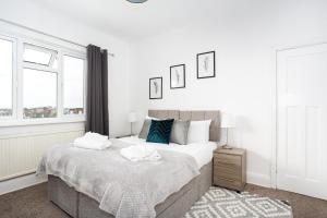 滨海绍森德Large 4 Bed in Southend, near shops/cafés/beach!的一间卧室配有一张床,上面有两条毛巾