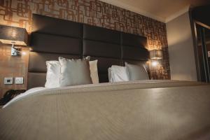 科格索尔埃塞克斯高尔夫&乡村俱乐部酒店的一间卧室配有一张大床和大床头板