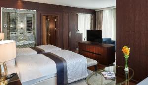 伊斯坦布尔Elite World Grand Istanbul Basın Ekspres的一间卧室配有一张床、一张书桌和一台电视