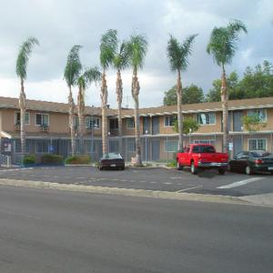 范奈斯凡奈斯海兰德汽车旅馆的停车场里一座棕榈树和一辆红色卡车的建筑