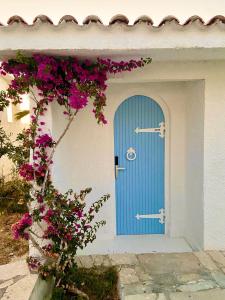 锡蒂亚LASSION GOLDEN BAY Sea view的一座带粉红色花朵的建筑上的蓝色门