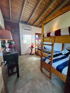 璜多里奥Casa en Villas Jubey con acceso al Hotel Emotion By Hodelpa的一间卧室设有两张双层床和一张带台灯的桌子。