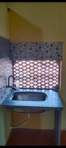 戴维格Om Laxmi Narayan Homestay的带窗户的浴室内的盥洗盆