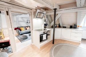 施瓦巴赫XZLLENZ: Exquisit, Fachwerk, Dachterrasse - Wohlfühlen的厨房和带白色橱柜的客厅