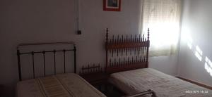 穆拉CASA RURAL EN LA HUERTA DE MULA的一间卧室设有两张床和窗户。