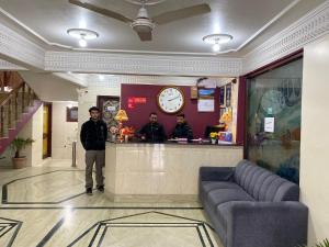 斯利那加Hotel City Plaza, Srinagar的两个男人站在餐厅柜台