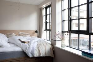 哥本哈根Bob W Østerbro Copenhagen的一间卧室配有一张带白色床单和窗户的床。
