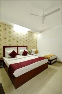 新德里Hotel Claytone Near Delhi Airport的一间卧室配有一张带红色和白色枕头的大床