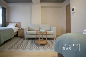 大阪CityStay難波南的配有床、椅子和桌子的房间