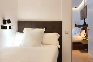 马德里Woohoo Rooms Boutique Luna的卧室配有白色的床铺和白色的枕头