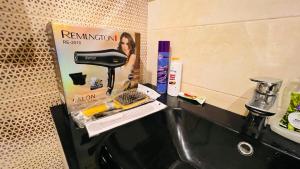 伊斯兰堡High Rise Executive Apartments Facing Centaurus Mall Islamabad的浴室柜台配有带吹风机和搅拌器的盥洗池。