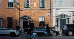 都柏林7号酒店的一个人在建筑物前骑着自行车