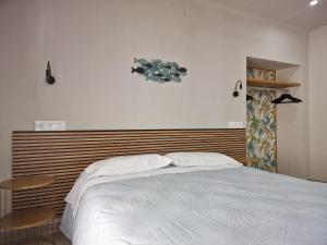 莱斯卡拉Pensió i Apartament Torrent的卧室配有白色的床和木制床头板