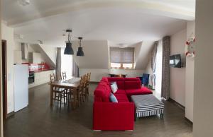 姆热日诺Faro Resort的客厅配有红色的沙发和桌子