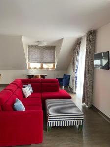 姆热日诺Faro Resort的客厅配有红色的沙发和桌子