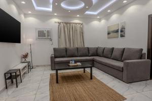 麦地那Luxurious Family 3 Bedroom Apartments 10 Mins Drive to Al-Masjid Nabawi - Qaswarah residence的客厅配有沙发和桌子